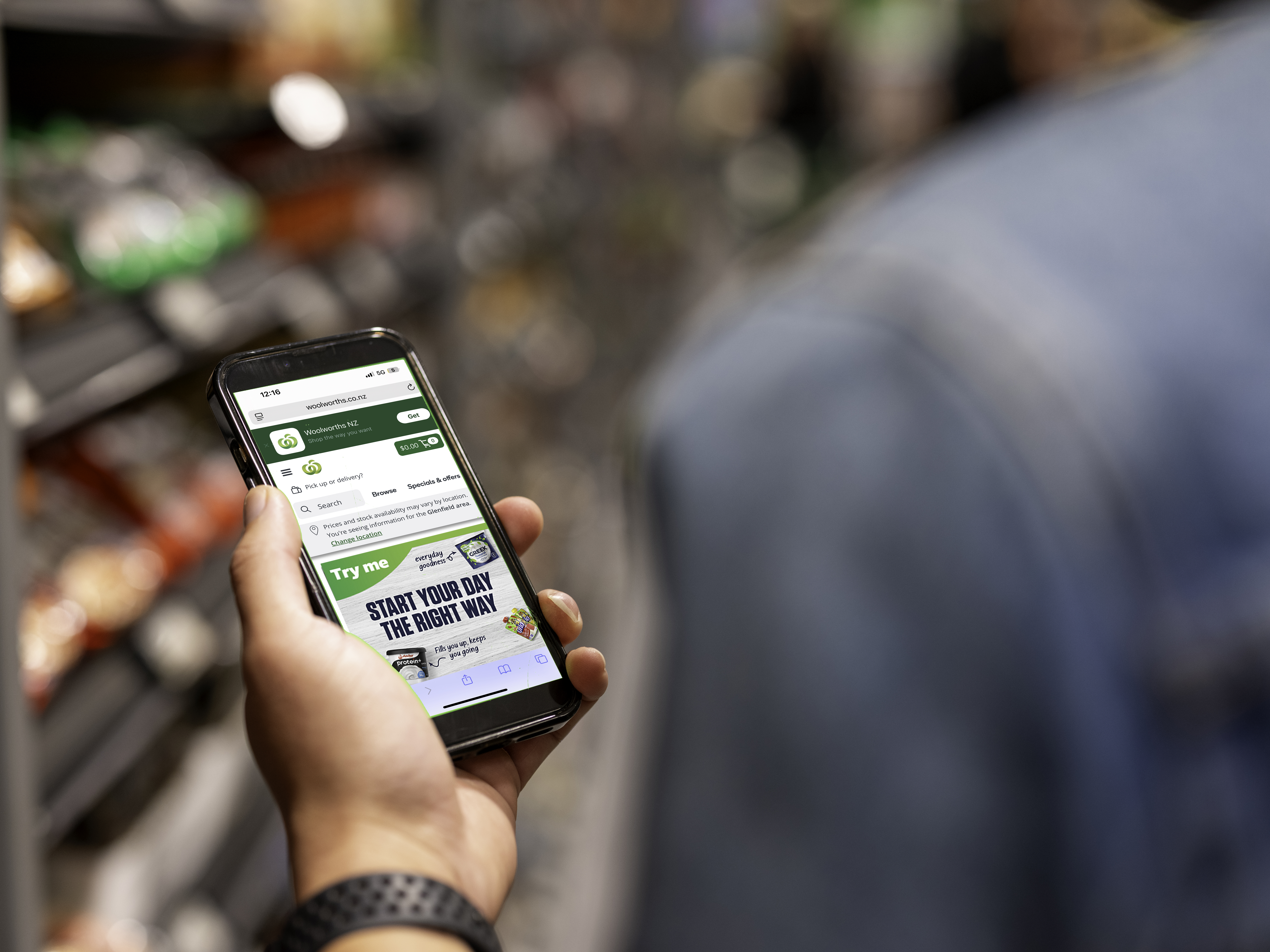 woman drinking from a cup and looking at laptop